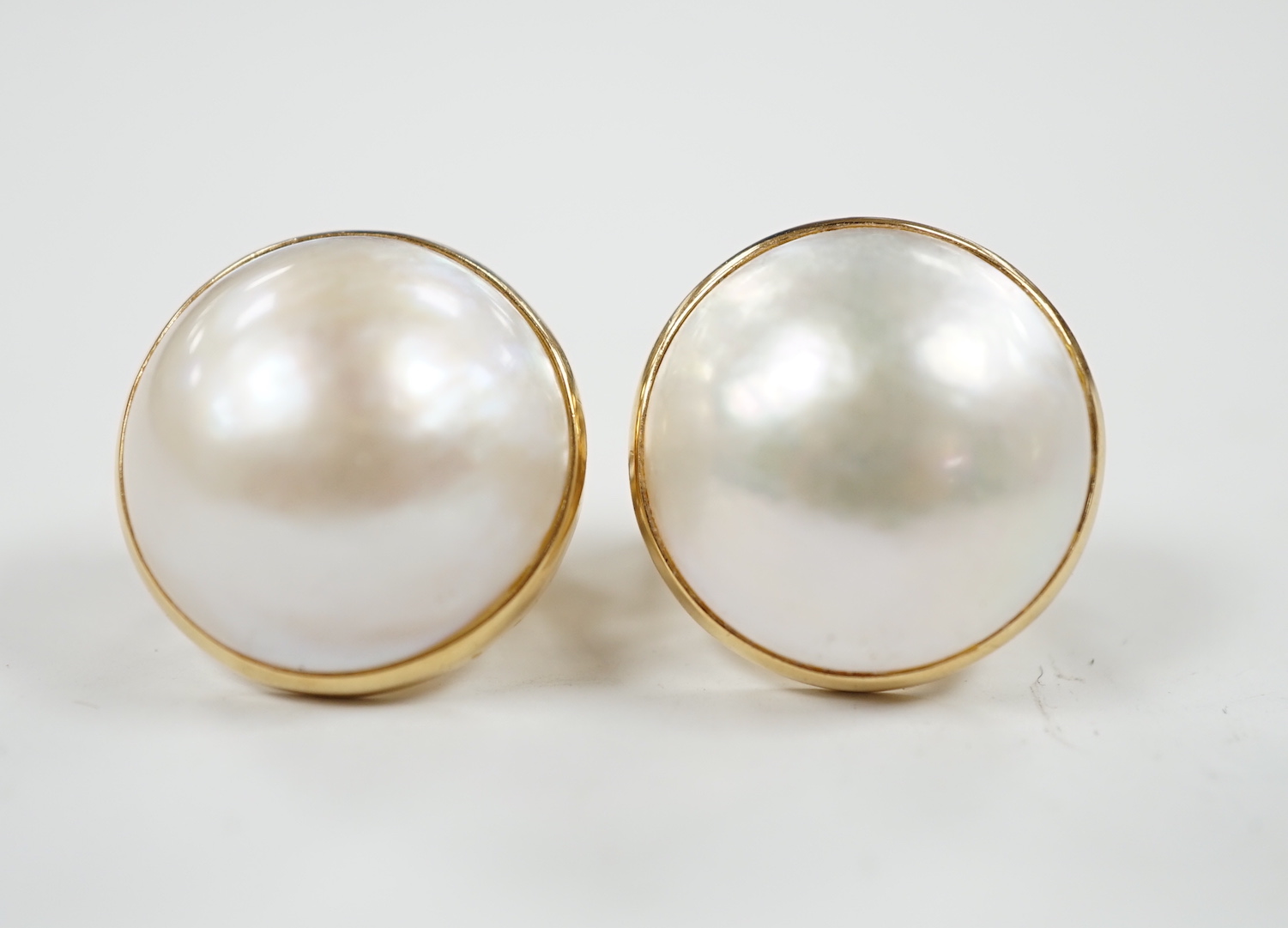 A modern pair of 750 yellow metal and mabe pearl set earrings, diameter 18mm, gross weight 11.9 grams.